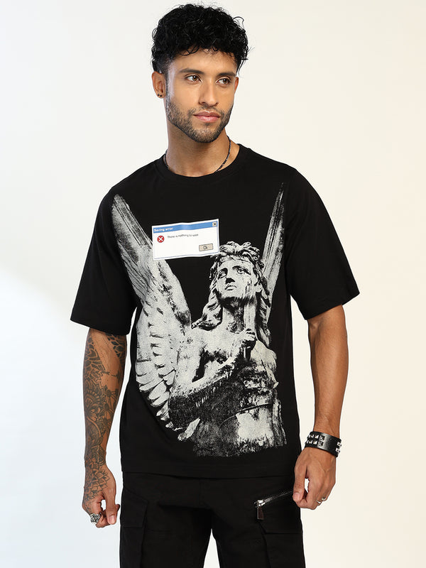 A man wearing a black graphic t-shirt featuring a large black and white print of an angel statue with a computer virus screen overlay, paired with black cargo pants against a plain white background.