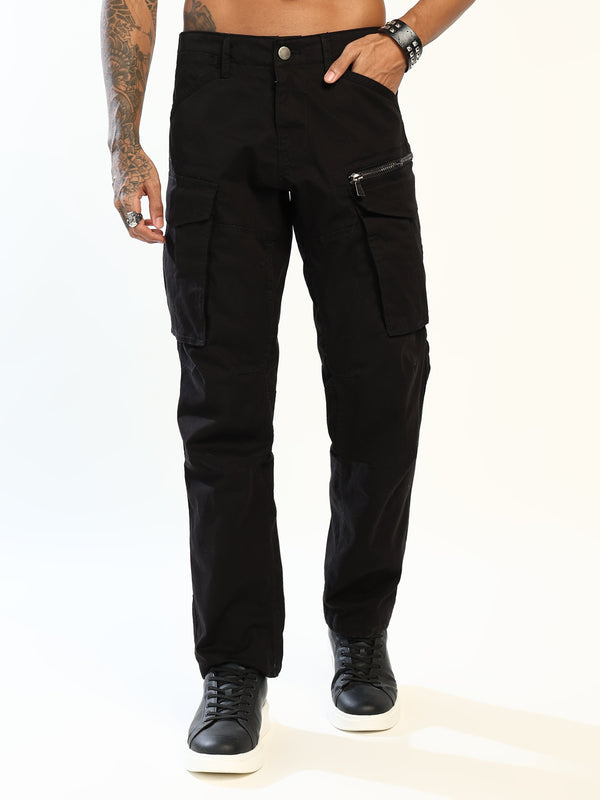 Black cargo pants with a zippered pocket on the left thigh, shown on a model wearing black sneakers against a white studio background.