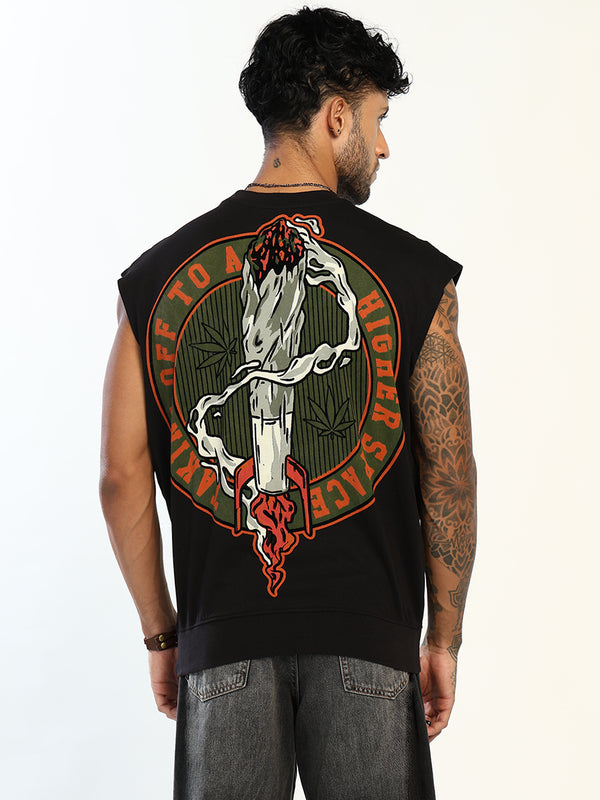A man viewed from the back wearing a black sleeveless t-shirt with a large graphic print on the back. The graphic features a white smoking joint with green smoke, a red flower on top, and a red circular border with the text 'TO A HIGHER SAGE'.