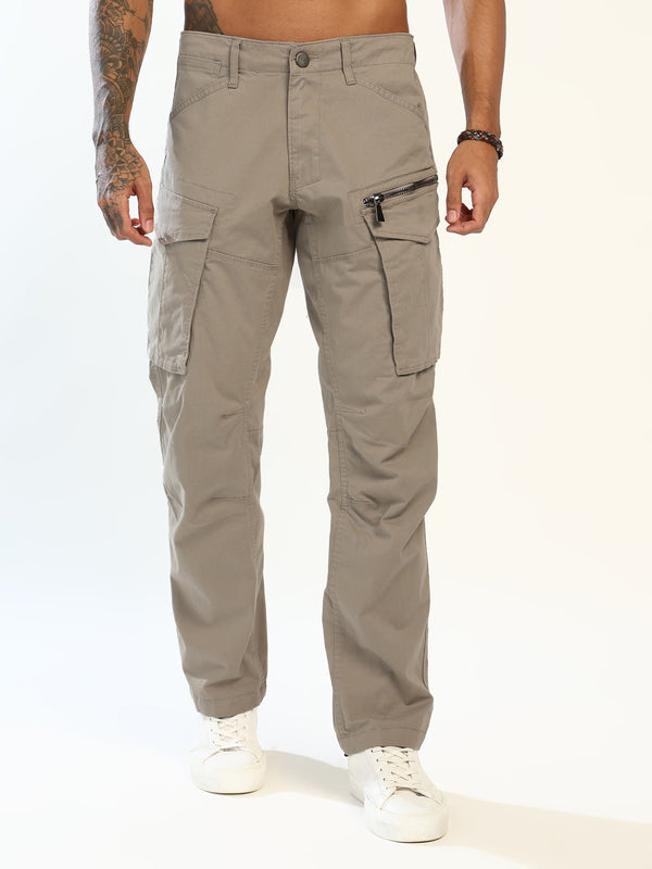 A person modeling a pair of straight-leg cargo pants in a light taupe-gray color, paired with white sneakers against a clean white studio background.